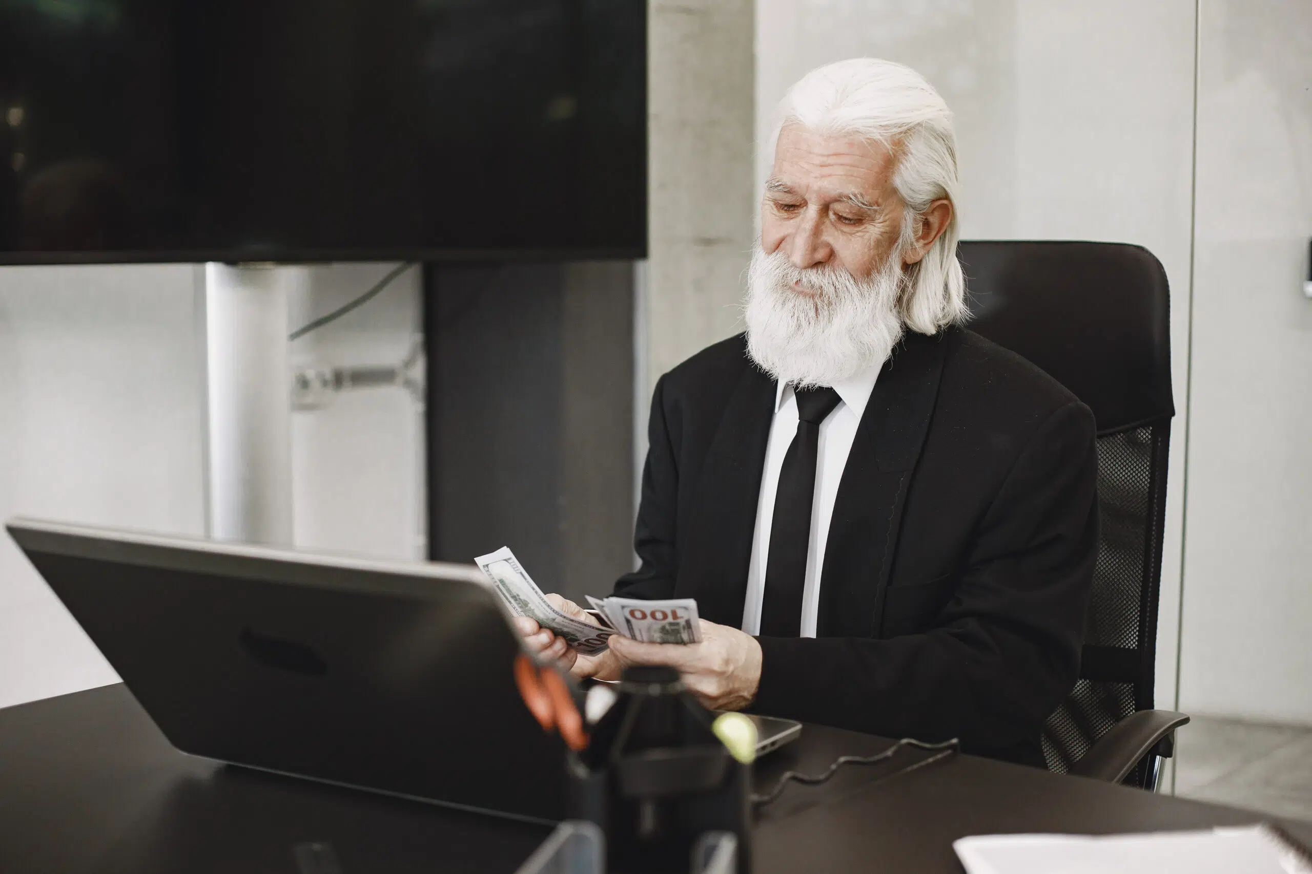 Old-fashioned man sitting at the table. Elegant man at the office. Senior with a money.